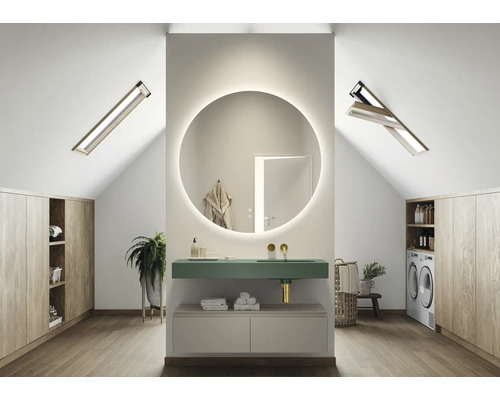 Modernt badrum på vinden med rund spegel, tvättställ, tvättmaskin och träskåp
