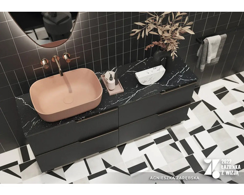 Modernt badrum med tvättställsskåp, bänkskiva och geometriska plattor