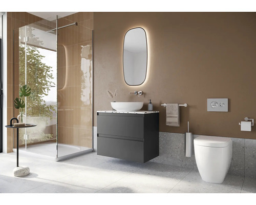 Modernt badrum med dusch, tvättställ, spegel och toalett.