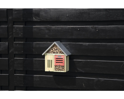 Insekthotell av trä på en mörk trävägg