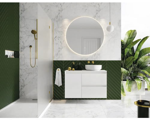 Modernt badrum med dusch, tvättställ, rund spegel och växter