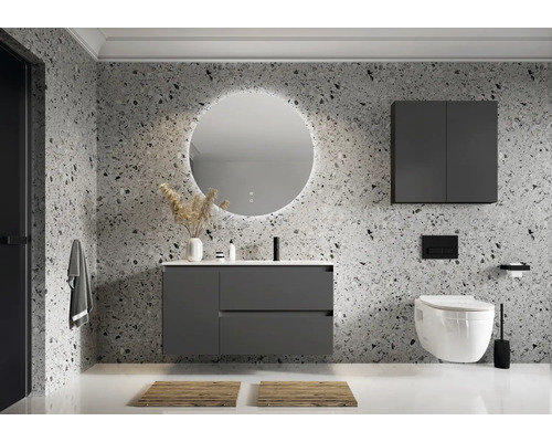 Badrum med handfat, spegel, hängande skåp och vägghängd toalett framför en terazzovägg