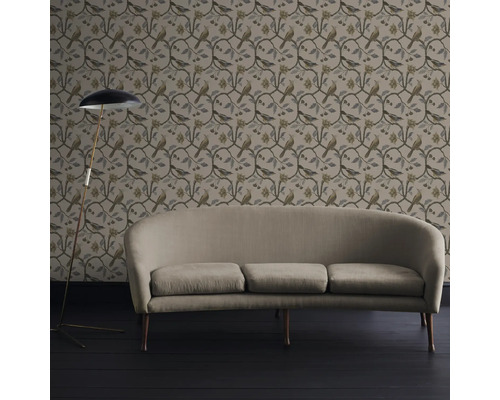 Vardagsrum med tapet med fågelmönster, soffa och golvlampa.