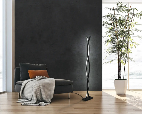 Modernt vardagsrum med fåtölj, krukväxt och spiralformad golvlampa