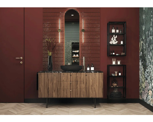 Badrum med tvättställ, spegel, kakel och hyllor för badrumsartiklar.