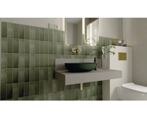 Badrum med grönt kakel, handfat och spegel