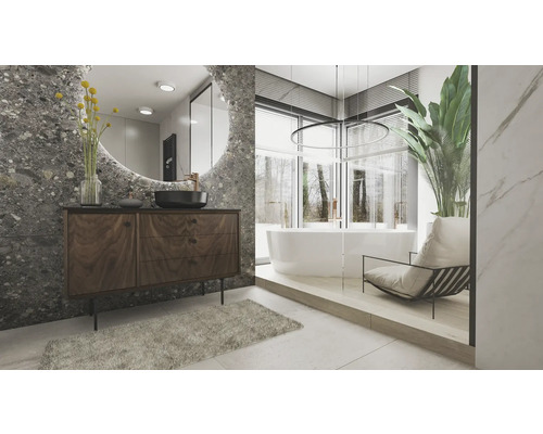 Ljust badrum med tvättställ, spegel, badkar och fåtölj.