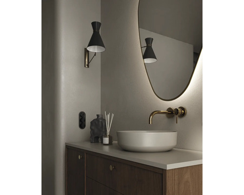 Badrum med handfat, vägglampa och spegel