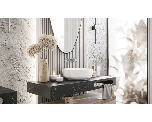 Badrumsdesign med handfat, spegel och dekorativa element på en mörk marmorskiva