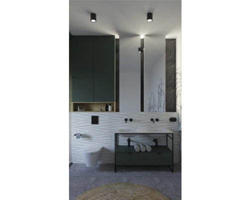 Ljust badrum med handfat, spegel, toalett och badrumsmöbler för ett organiserat utrymme.