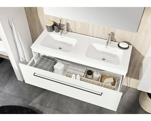 Badrum med dubbla handfat, armaturer och öppen låda för förvaring av badrumsartiklar.