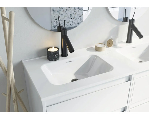 Modern badrum handfat med blandare, spegel och dekoration.