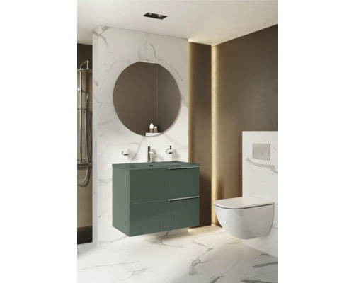 Modernt badrum med tvättställsskåp, rund spegel och vägghängd toalett för en stilfull atmosfär.