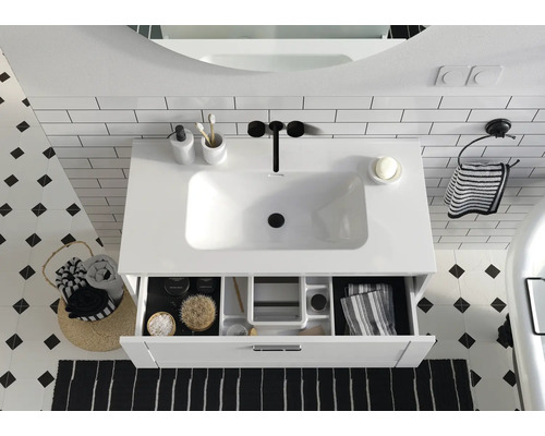 Badrumshandfat med öppen låda, kompletterat med tillbehör för en stilfull inredning.