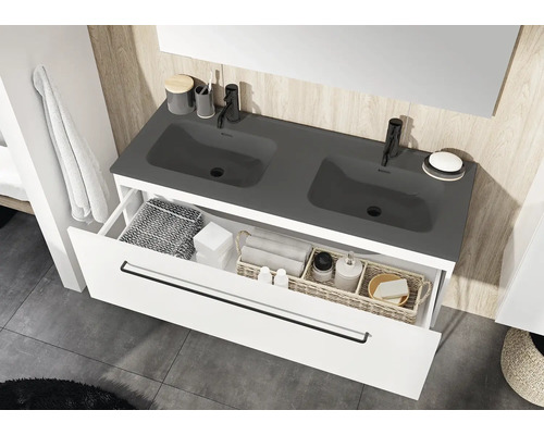 Badrum med tvättställsskåp, dubbla handfat och öppen låda för förvaring av badrumsartiklar.