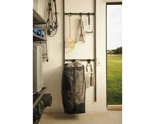 Organisationssystem med förvaringslösningar och diverse redskap på en vägg.