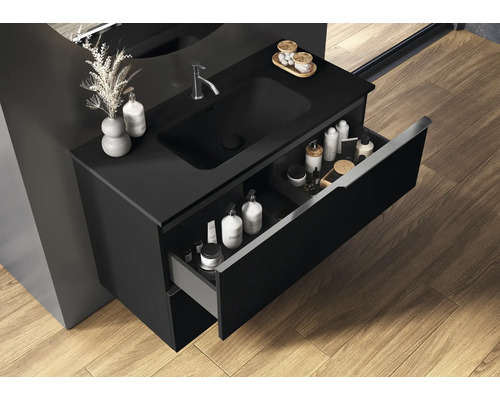 Svart tvättställsskåp med öppen låda i badrummet