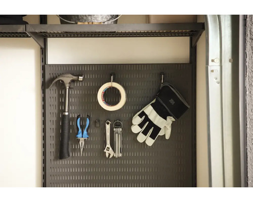 Verktygsvägg med hammare, tång, tejp, skiftnyckel och handskar.