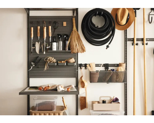 Organiserad verktygstavla med trädgårdsredskap, slang och förvaringsbehållare