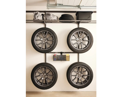 Fyra däck hänger på ett väggfäste i ett garage.