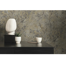 Dekorativ scen med blommig tapet, skulptur och växt på en byrå