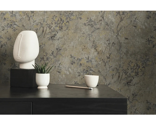 Dekorativ scen med blommig tapet, skulptur och växt på en byrå