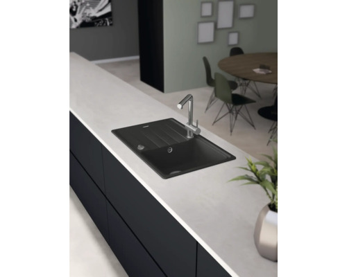 Svart diskho med kran på en bänkskiva i köket.