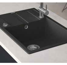 Svart diskho med avrinningsyta och armatur på en bänkskiva