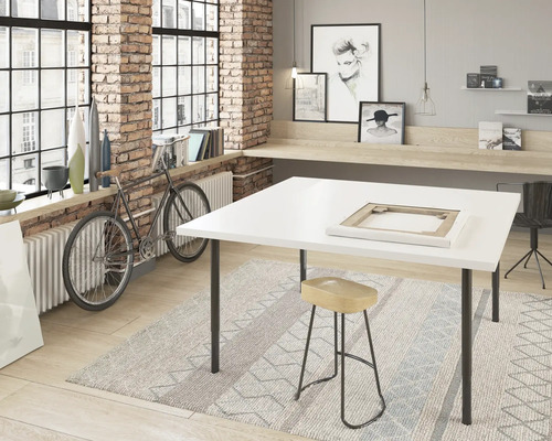 Arbetsrum med vitt bord, pall och cykel framför ett fönster