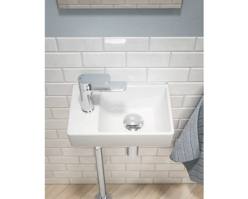 Kompakt badrum med handfat, kran och handduk