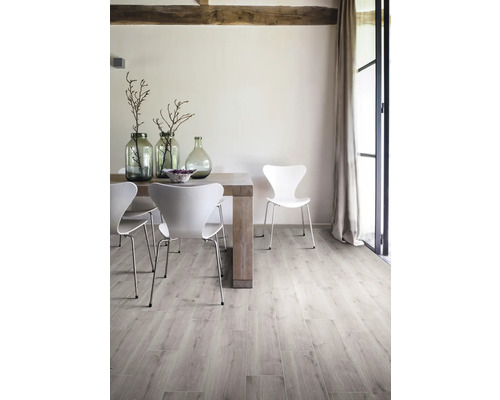 Ljust rum med matbord, stolar och trägolv.