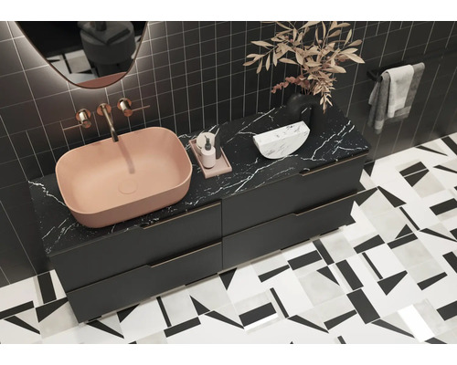 Modernt badrum med tvättställsskål, underskåp och geometriska plattor.