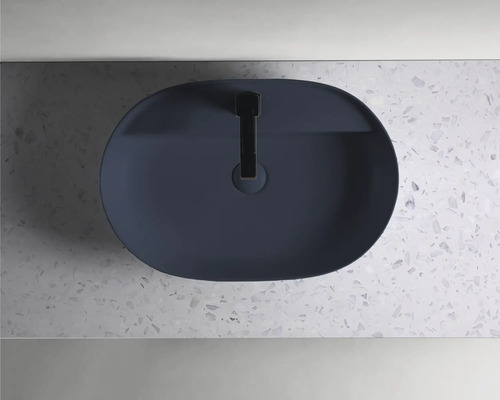 Ovalt tvättställ med blandare på en bänkskiva