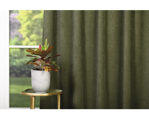 Dekorativt vardagsrum med gardin, växt och sidobord