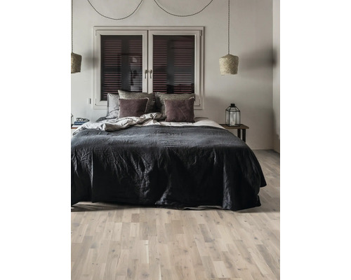 Sovrum med säng, sänglampa och fönster med persienner