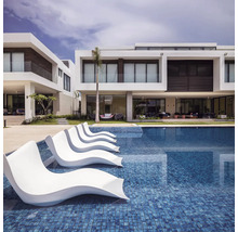 Pool med solstolar och moderna bostadshus i bakgrunden