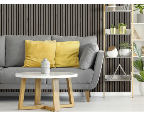 Vardagsrum med grå soffa, gula kuddar, vitt bord och träpanelvägg