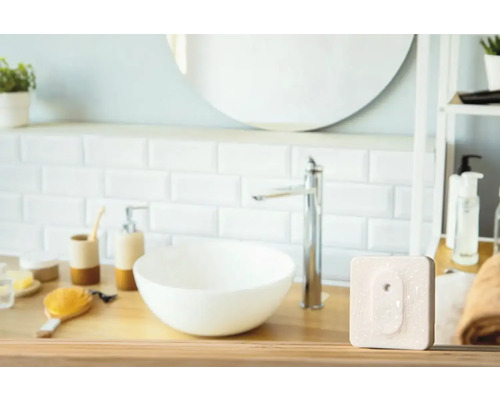 Badrum med handfat, spegel och radiatortermostat