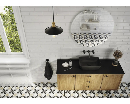 Ljust badrum med handfat, underskåp och mönstrade kakelplattor