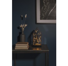 Dekorativ arrangemang med LED-lampa, vas, böcker och inramad bild på ett bord