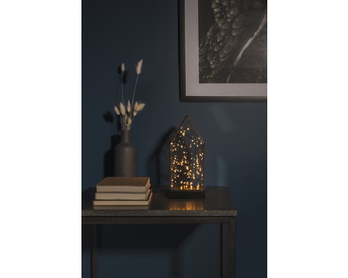 Dekorativ arrangemang med LED-lampa, vas, böcker och inramad bild på ett bord