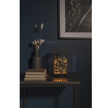 Dekorativ bordslampa med varmvita ljus på ett bord