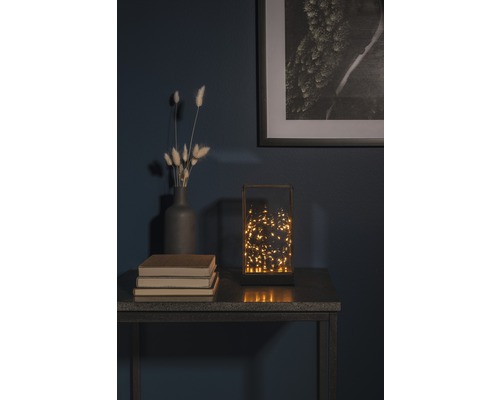 Dekorativ bordslampa med varmvita ljus på ett bord