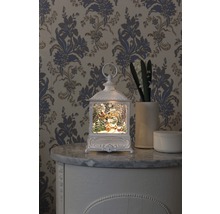 Dekorativ lykta med julmotiv på en byrå