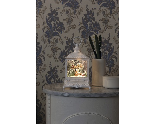 Dekorativ lykta med julmotiv på en byrå