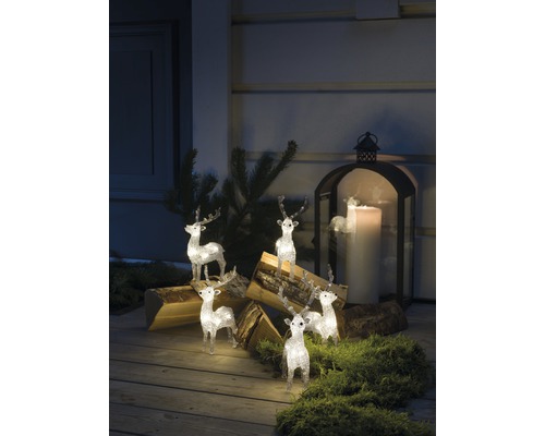 Dekorativ scen med upplysta renfigurer, vedträn och en lykta
