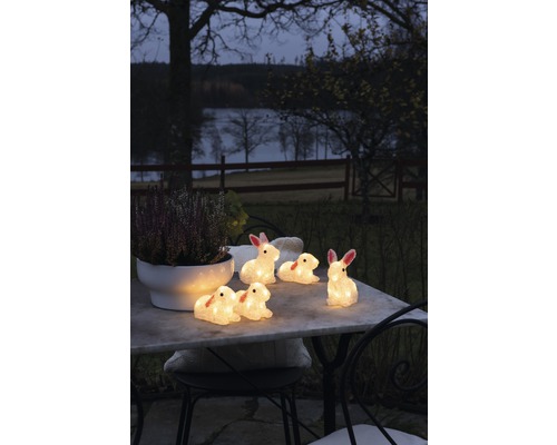 Dekorativa kaninfigurer med belysning på ett trädgårdsbord