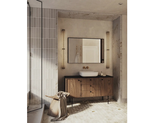 Ljust badrum med tvättställsskåp, tvättställ ovanpå bänken, spegel och belysning