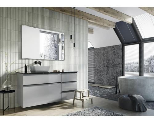 Badrum med tvättställsskåp, spegel och fristående badkar