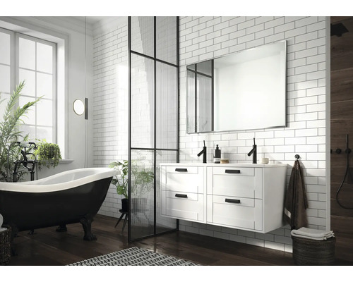 Ljust badrum med fristående badkar, tvättställsskåp och duschvägg